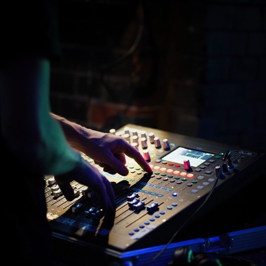 a person using a sound mixing console in a dark room